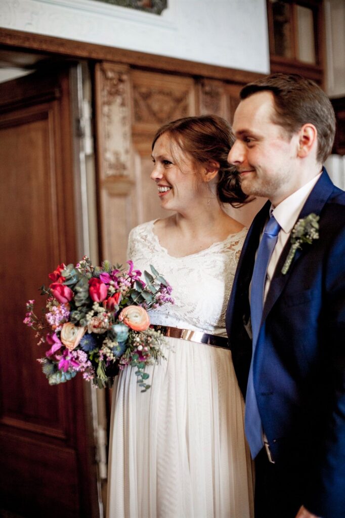 Hochzeitsfotograf berlin fotografiert Paar im Standesamt Pankow mit buntem Blumenstrauss