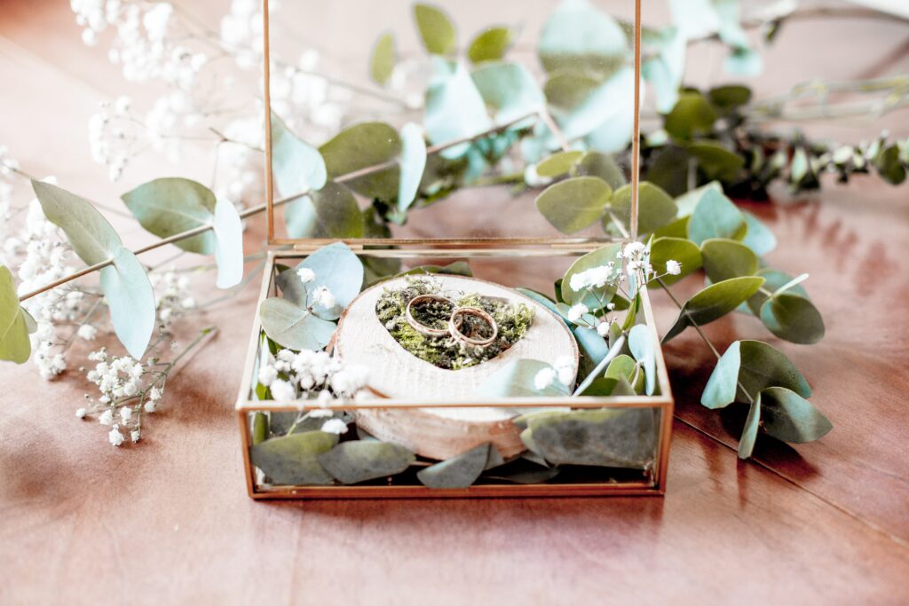 Hochzeitsfotograf Brandenburg Ringbox aus Glas mit Goldrand und mit Eukalyptus und goldenen Trauringen
