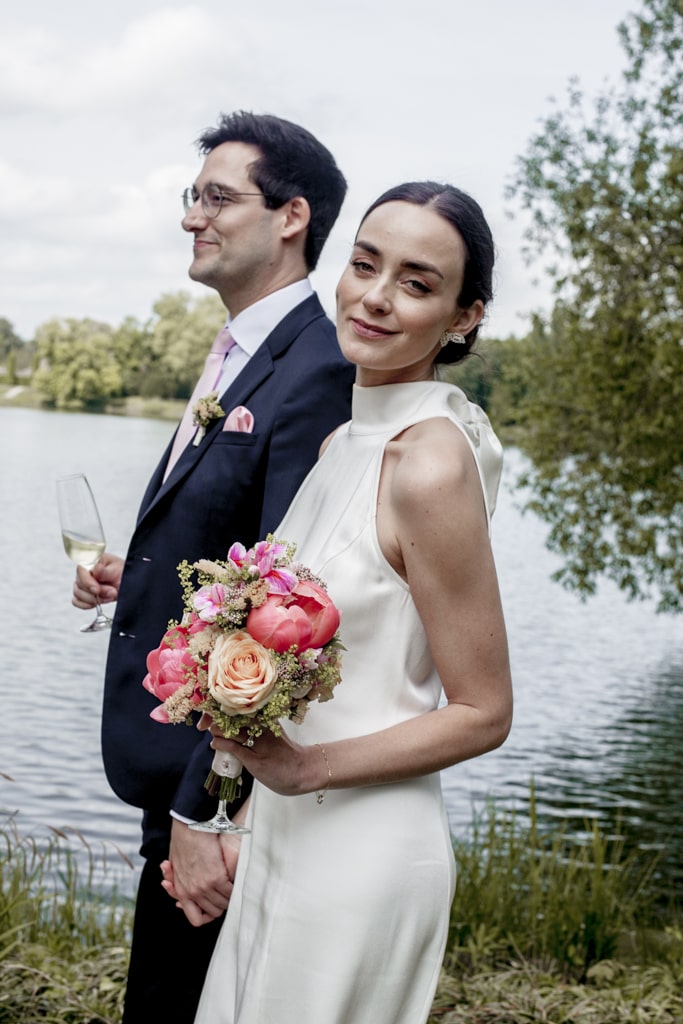 Hochzeitsfotograf Peitz Brautpaar spaziert am Wasser und Braut lächelt in die Kamera