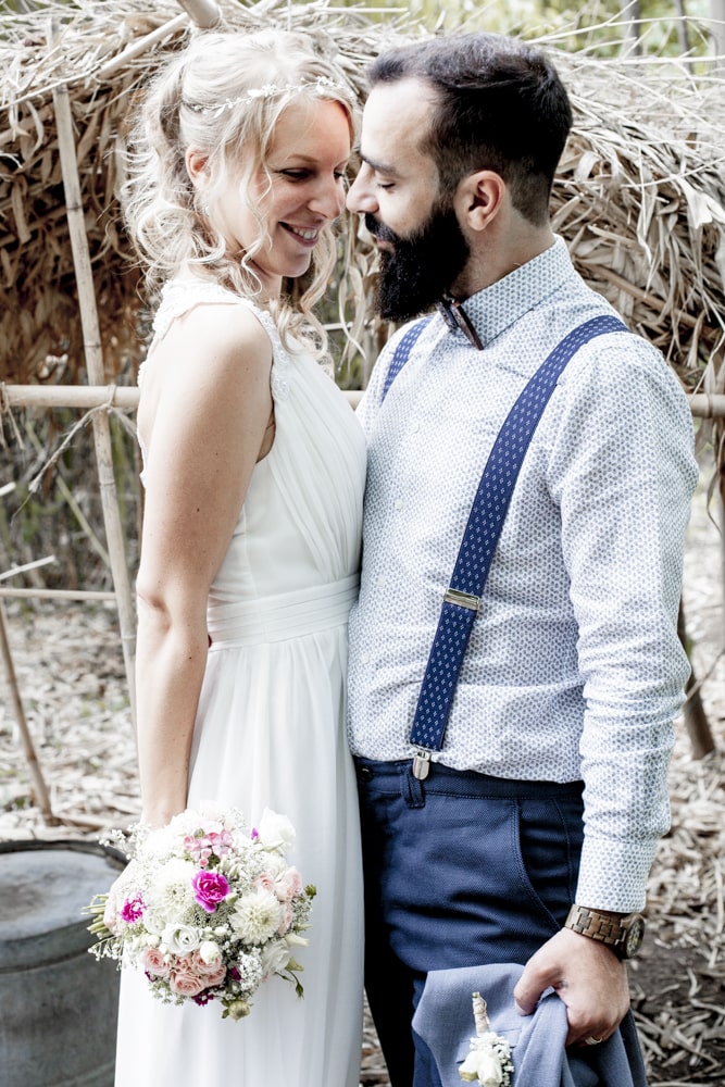 Hochzeitsfotograf Peitz Brautpaar vor einem Heuballen schaut sich lächelnd an und flirtet