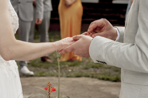 Hochzeitsfotograf Berlin Bräutigam steckt braut den Ring an den Finger während der Trauung in Richtershorn am See