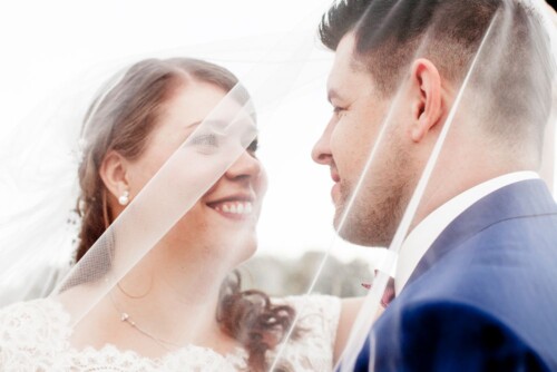 Hochzeitsfotograf Berlin Brautpaar mit Schleier kurz vor dem Kuss und lächelnd Nahaufnahme