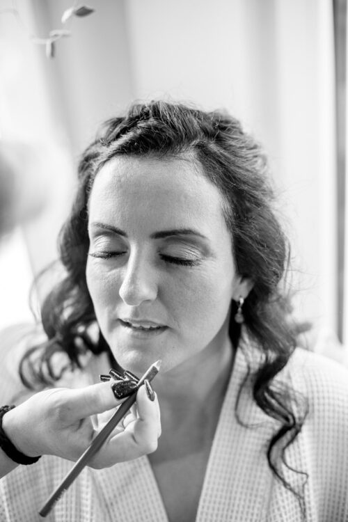 Hochzeitsfotograf Brandenburg Getting Ready Braut wird geschminkt bei Brautstyling in schwarz-weiss