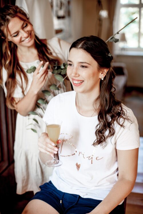 Hochzeitsfotograf Osnabrück Getting Ready Braut lächelt und trinkt Sekt